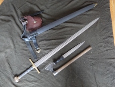 These are the weapons I carry on my belt at all times. First is my custom XIIIa war sword from John Lundemo of Odinblades. Its stats are 52 inches long overall and about 4.5 lbs. The blade is 5160h and has to be the hardest and most flexible blade Ive ever seen. Its POB is about 3 1/2 inches up from the guard. A big sword but lively, also Im 6'8 so it evens out. Next is a cold steel norse hawk and a dirk built on an old windlass dagger blade.