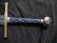 A close up of the hilt. Fittings are bronze. Handle is a fine grain black shark skin wet molded over a deeply grooved wood core with braided bronze wire fitted into the grooves. Best grip Ive ever felt on any sword.